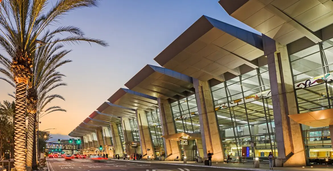 Exterior of San Diego International Airport terminal at sunset.